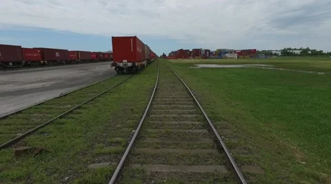Aerial scene moving forward a train rail and flying over containers on an import Vídeo Stock 59995372