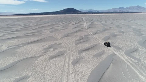 Aerial scene of van driving between sand dunes off road. Volcano at background Stockbeeldmateriaal 103391448