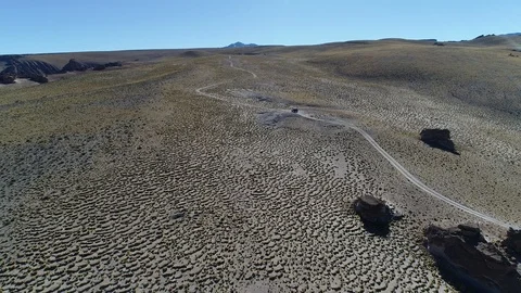 Aerial scene of van off road at high mountain, golden grasses and rocks Vidéo 103446477