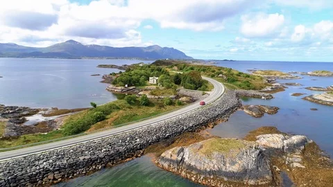 Aerial of scenic Atlantic Road in Norway with red car rear view Stock Footage