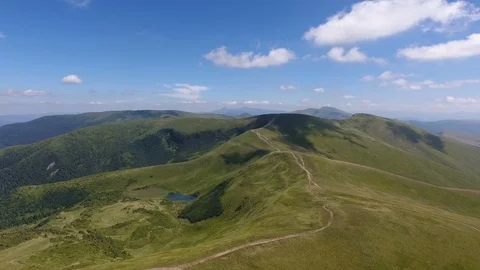 Aerial of a scenic Carpathian range with a tiny lake on a sunny day in summer Stock Footage 93940423