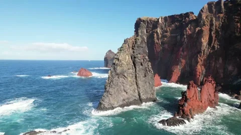 Aerial Semi Orbit Triangular Ocean Rock Surrounded by Vibrant Red 動画素材 170399113