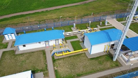 Aerial sequence capturing industrial plant with blue roofs and surrounding green Stock Footage 301891391