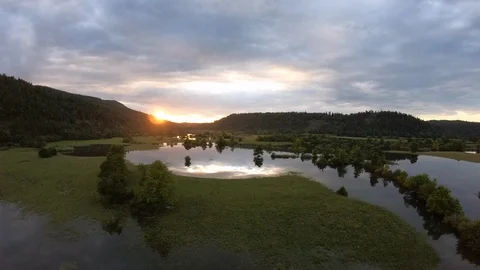 AERIAL Setting sun shining over the mountain reflecting in the lake Stock Footage 109348099