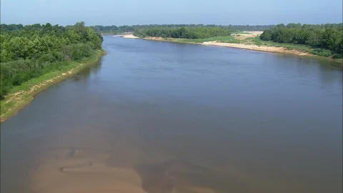 Aerial of shallow river passing through rural landscape on a sunny day, Low Stock Footage 109122142