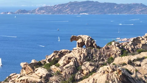 Aerial - Sharp Bear rock over the island of Sardinia and blue sea with sail boat Video stock 270158353