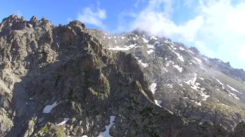 Aerial sharp rocky alpine peaks and exposed - Mountain Chain and Rockymountains Stock Footage 339424318