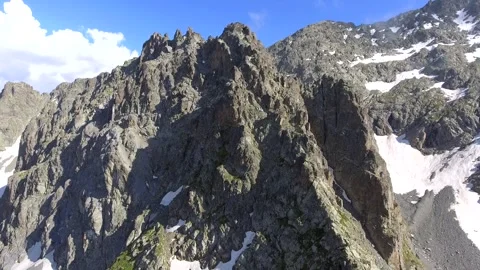 Aerial sharp rocky alpine peaks and exposed - Mountain Peaks and Mountain Chain Stock Footage 339424488