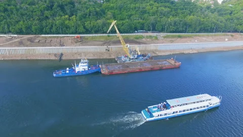 AERIAL: The ship sails on the river against the background of a lifting crane. Stock Footage 87014285
