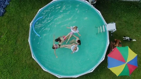 Aerial shooting of backyard pool with group of children swimming and having fun Stock Footage 140615049