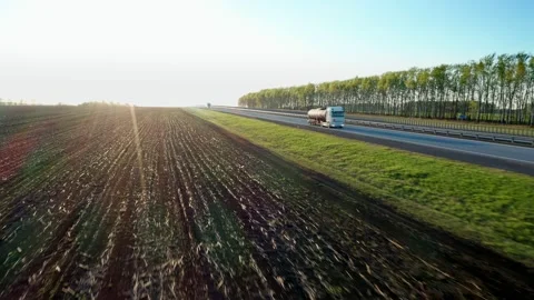 Aerial shooting in motion. A dark wheat-sown field near the regional track Stock Footage 154012452