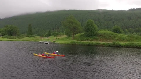 Aerial shot of 2 kayaks going down a river in the Scottish highlands Stock Footage 58912502