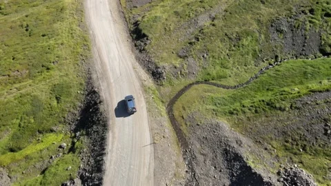 Aerial shot of 4x4 SUV car driving through the mountain dirt road Stock Footage