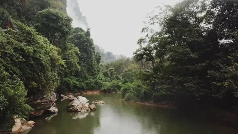 Aerial shot above the river between jungle trees. Rainy weather. Thailand Stock Footage 201415196
