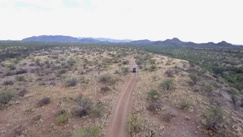 Aerial shot of an ATV rolling down a desert trail Stock Footage 76443284