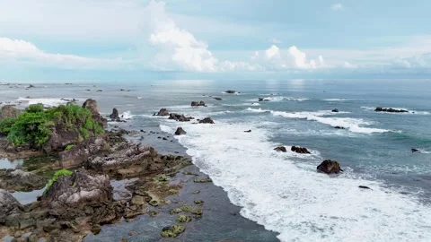 Aerial shot of beach with waves rolling the coastline for vacation and travel Stock Footage 308693040