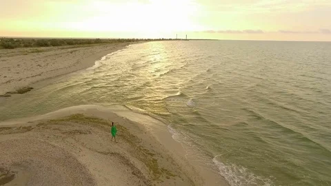Aerial Shot of a Beautiful Girl Walking Along a Seacoast in Slo-Mo Stock Footage