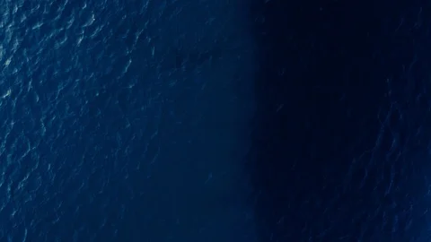 Aerial shot beautiful smooth water surface of dark blue clear sea with small Stock Footage 107780157