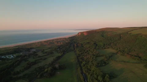 Aerial shot of Benone Coastline & train at sunset, North Coast, Northern Ireland Stock Footage