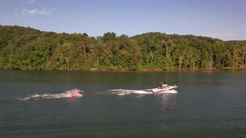 Aerial Shot Of Boat Pulling Three Inflatable Tubes In Lake, Drone Tracking Video stock 201761560
