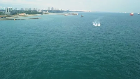Aerial shot of boat speeding through water, Singapore Stock Footage 106599792