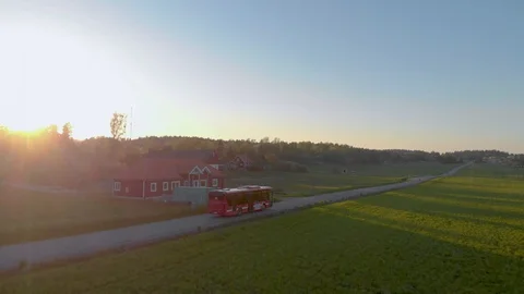 Aerial shot of bus driving on country road during sunset in Stockholm Stock Footage