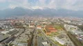 Aerial shot of busy city, intensive traffic on roads, mountain range on horizon 4k or 4k+ Resolution