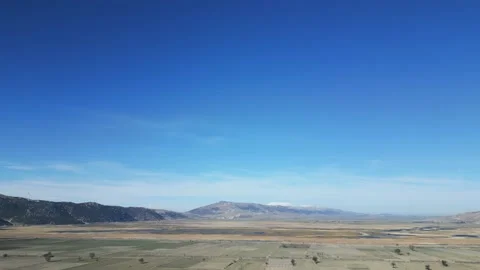 Aerial shot, the camera is flying through mountainous terrain, with windmills Stock Footage 233287145