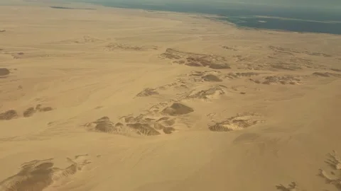 Aerial Shot Capturing Endless Sand Plains Meeting Sea With Rocky Shadows And Stock-Footage 337938864