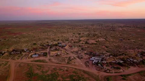 Aerial shot capturing the glowing desert sunset over a remote opal mining Stock Footage 285524029