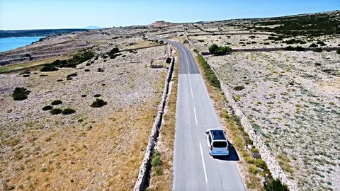 Aerial shot of car driving between the dry stone walls 4K Stock Footage