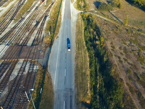 Aerial shot. Car driving on the road. Forest. Railway. Train. Sunny. Stock Footage