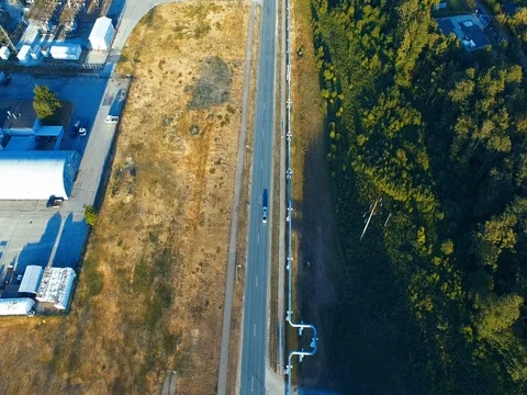 Aerial shot. Car driving on the road. Forest. Railway. Train. Sunny. Stock Footage