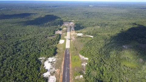 Aerial shot of a cargo plane speeding up and taking off on a tiny runway Stock Footage 103736411