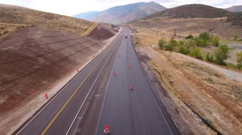 Aerial shot as cars drive through construction zone Stock Footage