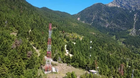 Aerial shot of cellular antenna surrounded by fir forest landscape Stock Footage 343945411