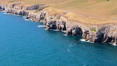 Aerial shot of the cliffs and caves along the Jurassic coast, Dorset, UK Stock Footage 345282037