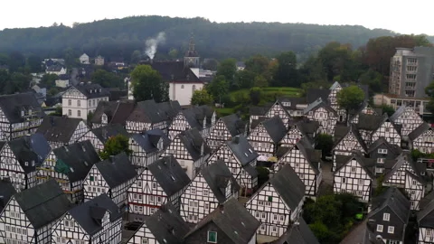 Aerial Shot Of Clock Tower On Hill In Town, Drone Flying Backwards Over Roofed Video stock 188174849