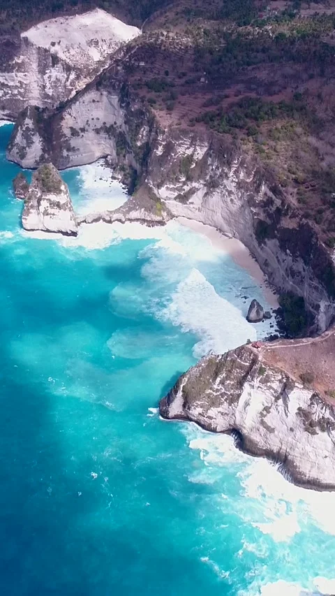 Aerial shot of coast with vertical cliffs, turquoise water and waves crashing Stock Footage 227101305