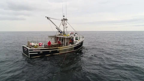 Aerial shot commercial ocean fishing boat checking lobster traps Stock Footage