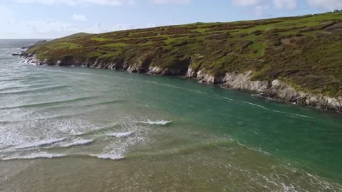 Aerial shot Cornwall seaside patchwork green and gentle waves pan to 動画素材 210330491