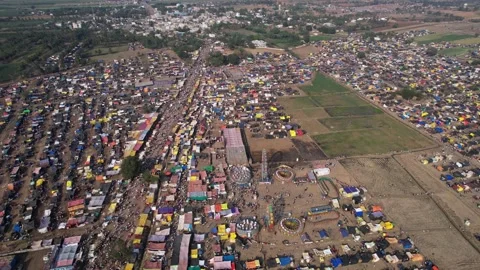 Aerial shot of a crowded county fair with colourful tents, shops, and devotee Stock Footage 233076572