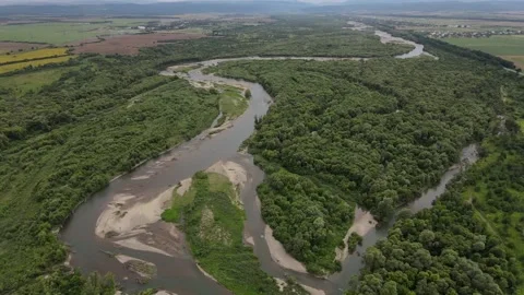 An aerial shot of the curvy river winding through heavily forested banks. Stock Footage