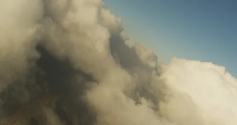 Aerial shot, day, cloud front halts at hill top barrier, angle pan up to show Stock Footage 115282598
