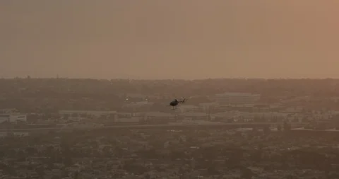 Aerial shot, day, high altitude zoom on helicopter flying over la at sunset, Stock Footage 115155953