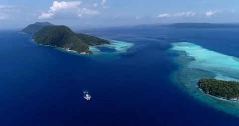 Aerial shot of diving boat going along tropical island and turquoise water Stock Footage 100351602