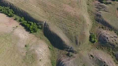 Aerial shot of the Dnipro area with fields, ridges and caves in hills in summer Stock Footage 88206325