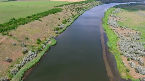 Aerial shot of the Dnipro, its hilly banks with rusty wetland on a sunny day Stock Footage 86850436