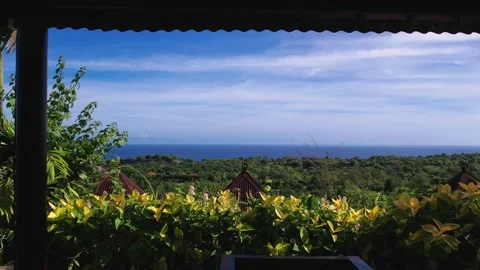 Aerial shot of drone camera flying through a gazebo towards Indian Ocean, Bali 스톡 동영상 246904133