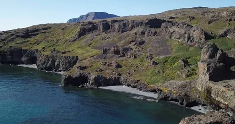 Aerial shot of drone pulling back from Arctic Island with two tourist guys Stock Footage 121424729